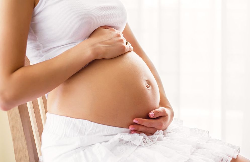 Schwangere Frau hält ihren Bauch