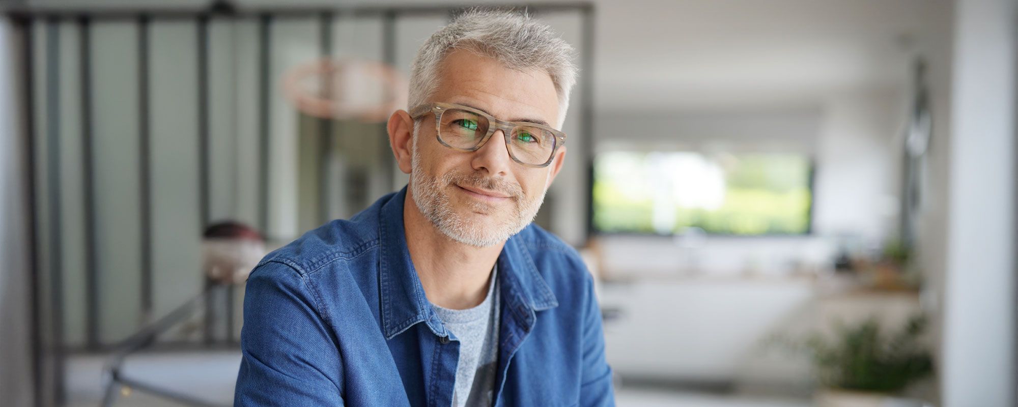 Mann mit Brille in moderner Wohnung