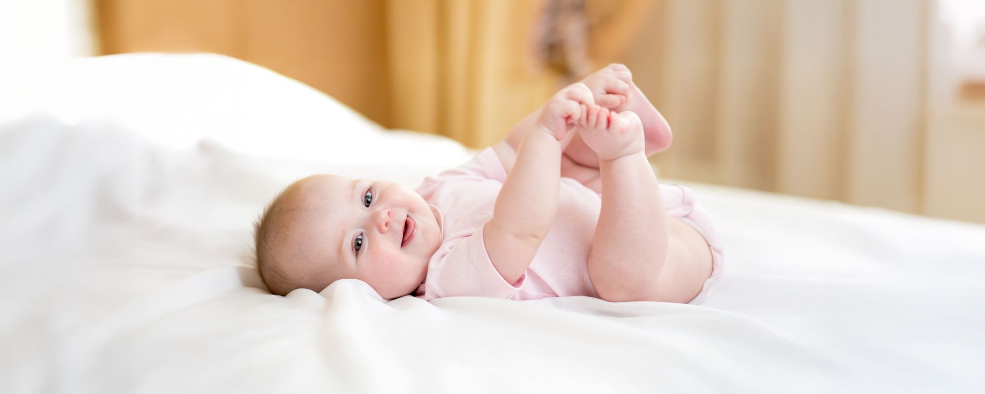 Lächelndes Baby auf dem Bett