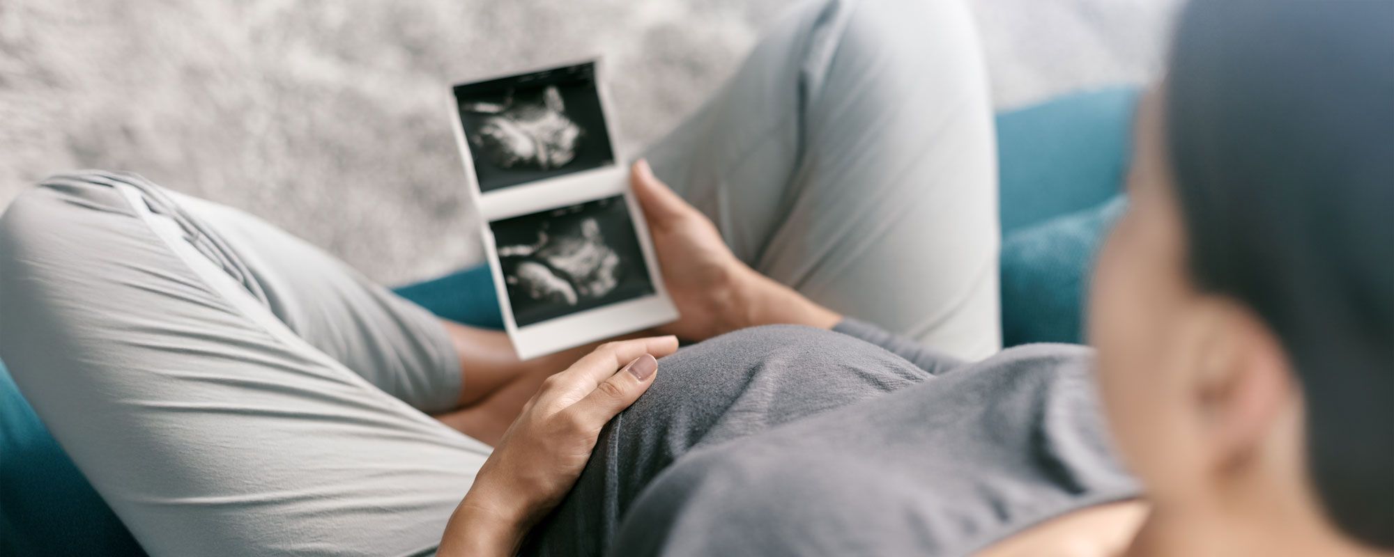 Schwangere Frau mit Ultraschallbildern